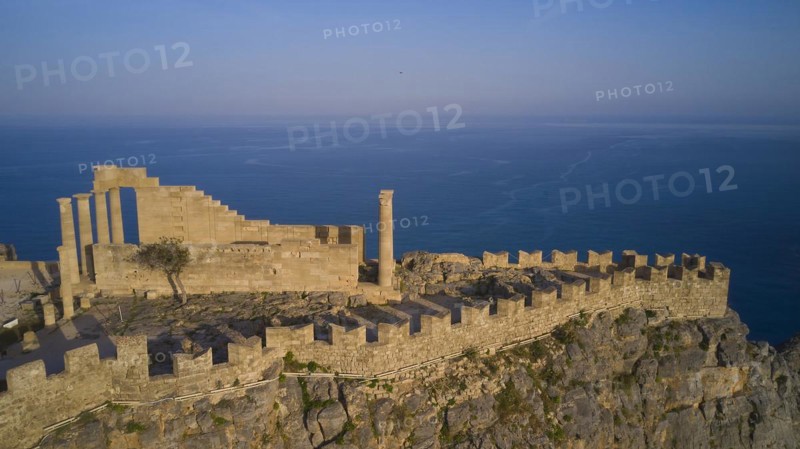 Drone shot, Acropolis of Lindos, late afternoon light, Temple of Athena Lindia, ruins on a rocky outcrop overlooking the vast sea, Archaeological site, Lindos, Rhodes, Dodecanese, Greek Islands, Greece, Europe