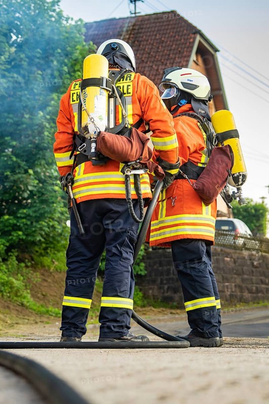 Two firefighters in orange uniform and breathing apparatus standing together, fire brigade, Enzklösterle, Black Forest, Germany, Europe