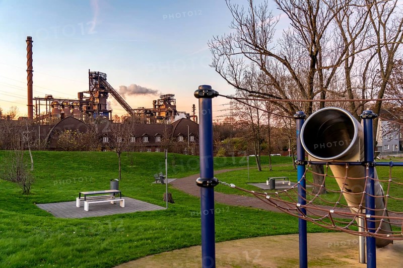Blast furnace Schwelgern 1, Black Giant, Schwelgern 2 ThyssenKrupp Steel plant Schwelgern in Duisburg-Marxloh belongs to the Bruckhausen steelworks, playground and fitness area Grüngürtel Nord, at Schwelgernstadion, sunset, North Rhine-Westphalia, Germany, Europe