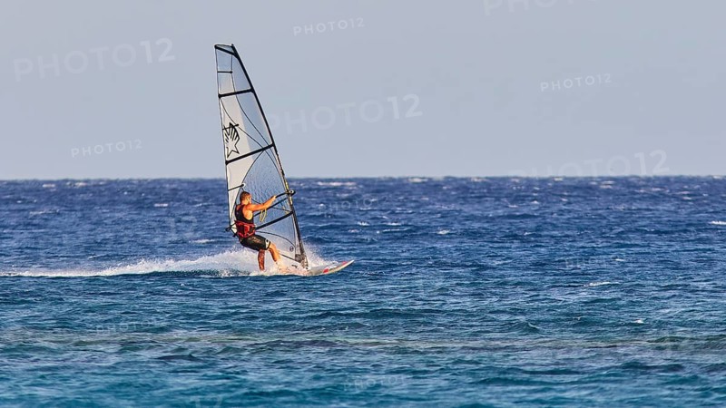 A windsurfer with a stylish sail glides over the sea surface, windsurfer, Meltemi windsurfing spot, Devils Bay, Paralia Vatha, Vatha Beach, south-east coast, Karpathos, Dodecanese, Greek Islands, Greece, Europe