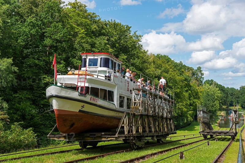 A boat is transported overland on a railway carriage, through a green landscape, ship Birkut, Buchwalde, Buczyniec, Upland Canal, Warminsko-Mazurskie, Warminsko-Mazurskie, Poland, Europe
