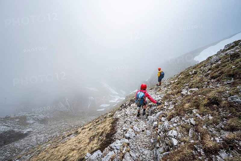 Two mountaineers on a narrow hiking trail, ascent to the Ackerlspitze, clouds moving around the mountains, Wilder Kaiser, Kaiser Mountains, Tyrol, Austria, Europe