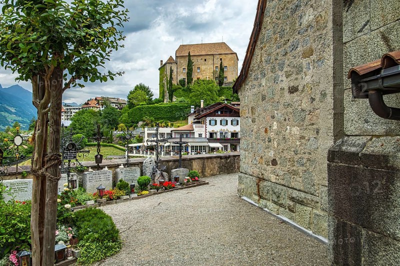 Picturesque cemetery with a view of Scena Castle, on the church hill of Scena above Merano, in the Burggrafenamt, South Tyrol, Italy, for editorial use only, Europe