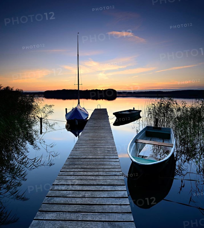 Quiet lake with jetty and boats after sunset at dusk, Großer Lychensee, Lychen, Brandenburg, Germany, Europe