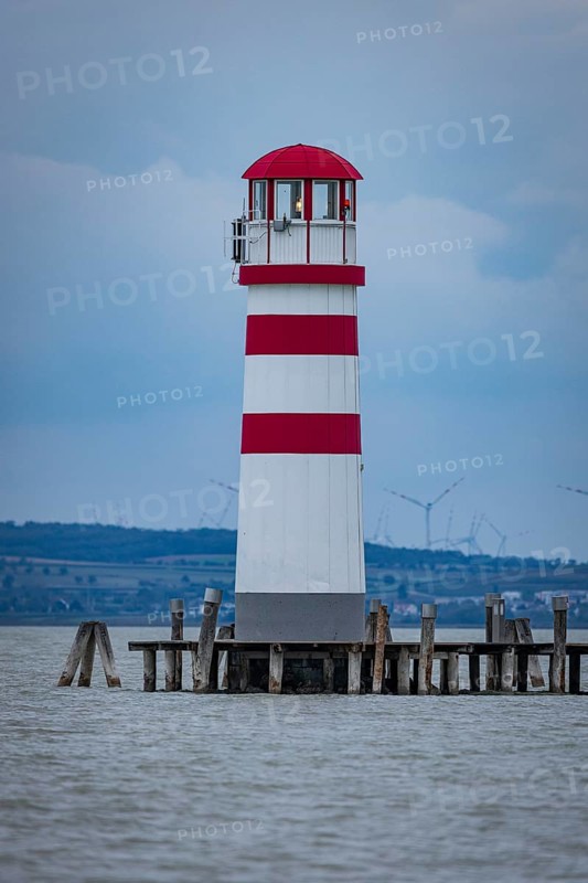 A lighthouse stands on a jetty in the water in front of a cloudy sky, Podersdorf, Burgenland, Austria, Europe