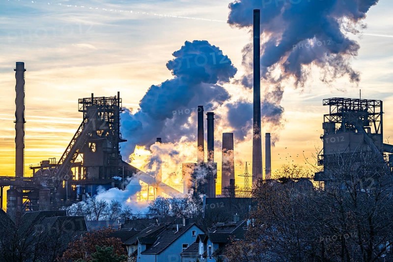 Blast furnace Schwelgern 1 and 2, ThyssenKrupp Steel plant Schwelgern in Duisburg-Marxloh belongs to the Bruckhausen steelworks, extinguishing cloud of the Schwelgern coking plant, sunset, North Rhine-Westphalia, Germany, Europe