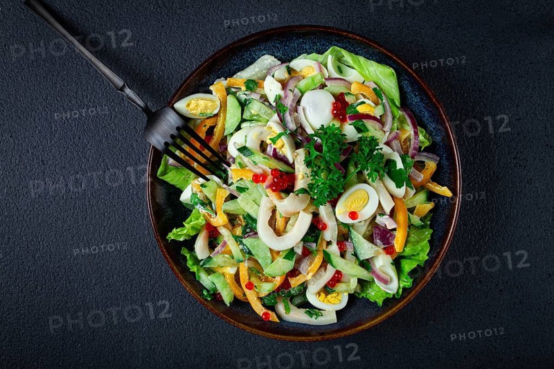 Salad with squid, fresh cucumber, eggs, sweet pepper, red onion, with dressing, homemade, no people