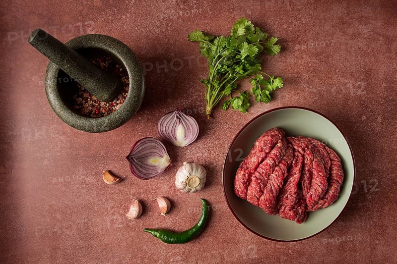 Fresh minced meat, raw, with spices and ingredients. on the table, preparation, top view