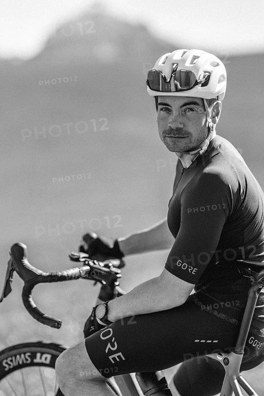 Road bike rider in spring near Halblech in the Allgäu in front of a picturesque backdrop of the Alps, Bavaria, Germany, Europe