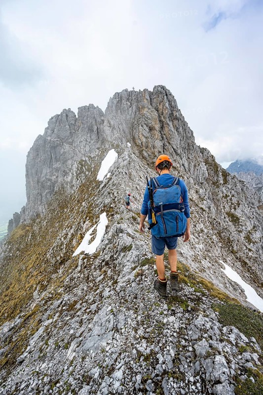 Mountaineers on the rocky ridge, behind the summit of the Ackerlspitze on the ascent to the Ackerlspitze, clouds moving around the mountains, Wilder Kaiser, Kaiser Mountains, Tyrol, Austria, Europe