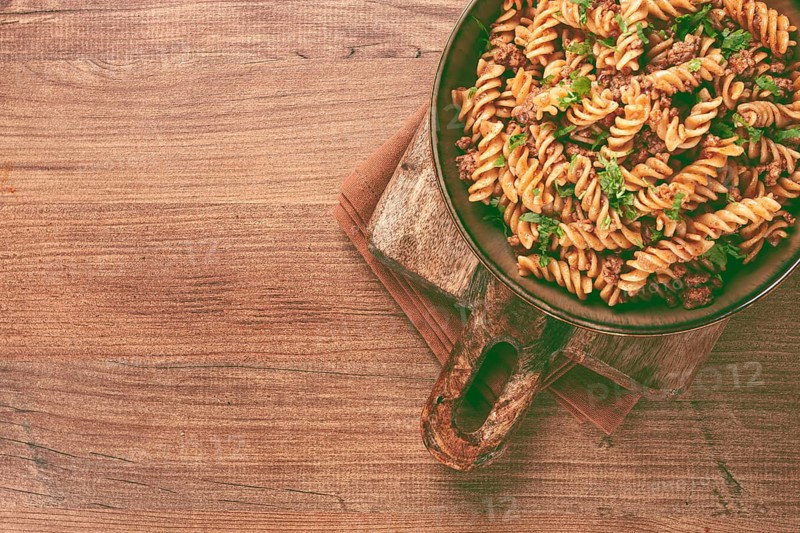 Pasta in the navy, pasta with minced meat, plate on a wooden table, homemade, fusilli pasta, without people
