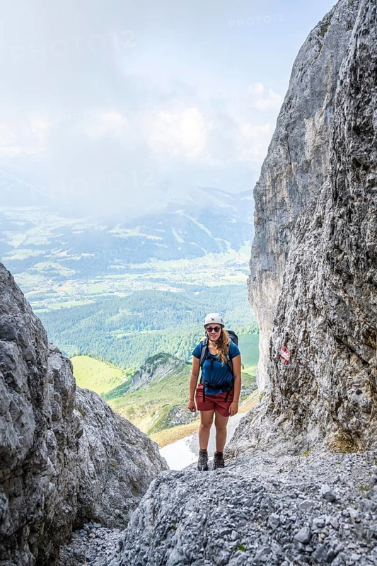 Female mountaineer with helmet climbing a rock face, ascent to the Ackerlspitze, Wilder Kaiser, Kaiser Mountains, Tyrol, Austria, Europe