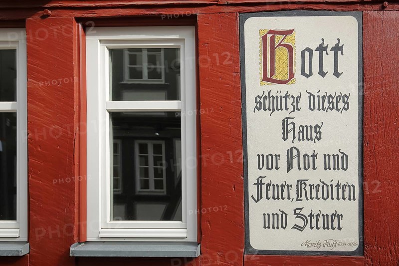 Quote by Moritz Kuhl: God save this house from misery and fire, loans and taxes, text, saying, inscription, saying, rhyme, tax, credit, loan, finance, banking, guard, guard, protect, preserve, preserve, misery, protection, half-timbered house with window, Butzbacher Zeitung Presse, Langgasse, Butzbach, Wetterau, Hesse, Germany, Europe