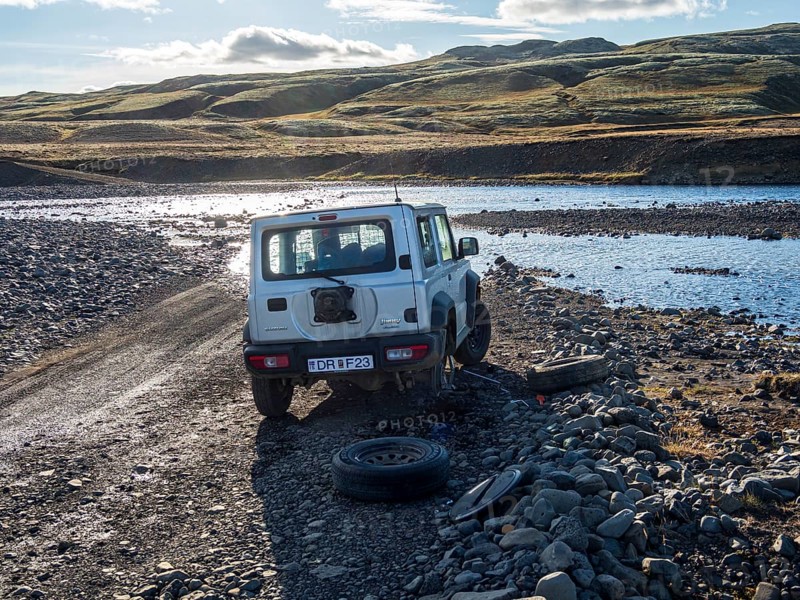 4x4 car with flat tire, change of tire at river crossing on mountain road F206, road to Laki crater or Lakagígar, interior highlands of Iceland, Suðurland, Iceland, Europe