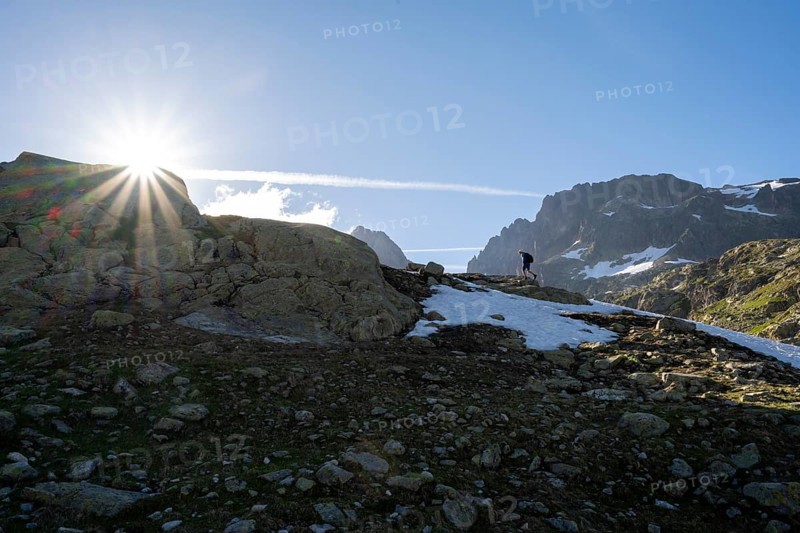 Climber on the ascent, sun star in the morning, Aiguilles Rouges, Chamonix-Mont-Blanc, Haute-Savoie, France, Europe