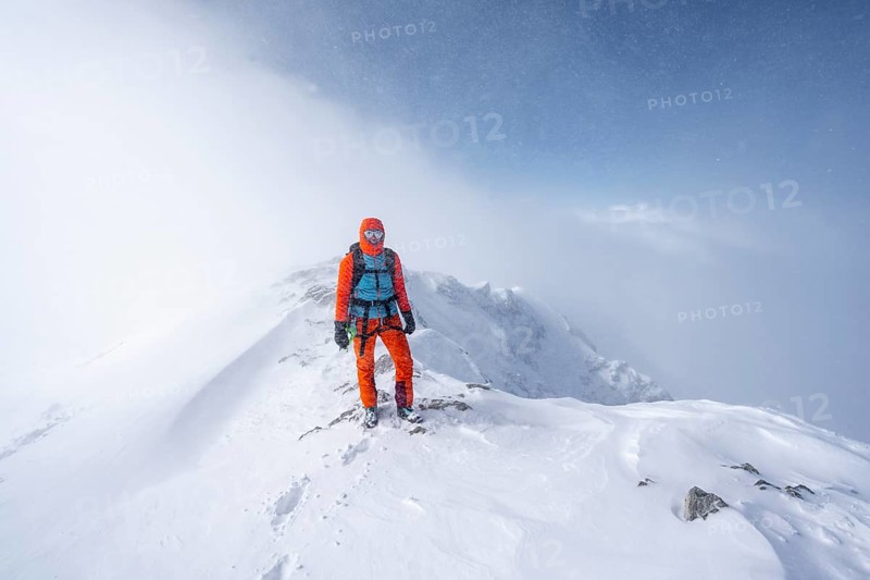 Ski tourer in snowy mountain landscape, at the summit of the Wildhorn, cloudy mood, high tour, Bernese Alps, Bernese Oberland, Switzerland, Europe
