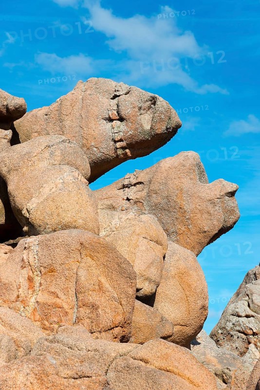 Large, eroded rock formations under a blue sky are reminiscent of faces, Ploumanac'h, Ploumanach, Perros-Guirec, Côtes-d'Armor, Brittany, France, Europe