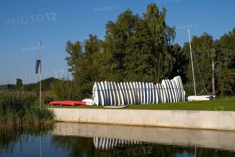 Surfboards standing next to each other in a stand on the Achterwasser, Ückeritz, Usedom Island, Baltic Sea, Mecklenburg-Western Pomerania, Germany, Europe