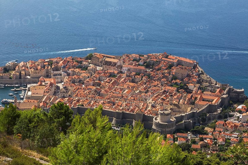 High angle view of old walled city of Dubrovnik with traditional terracotta clay tile rooftop buildings and adriatic sea taken from Mount Srd in late summer, Croatia, Europe
