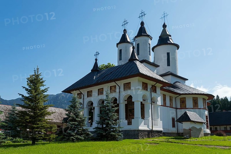 White orthodox church building with black roofs under a clear blue sky, Romanian Orthodox Monastery Cheia, Maneciu, Maneciu, Prahova, Wallachia, Romania, Europe