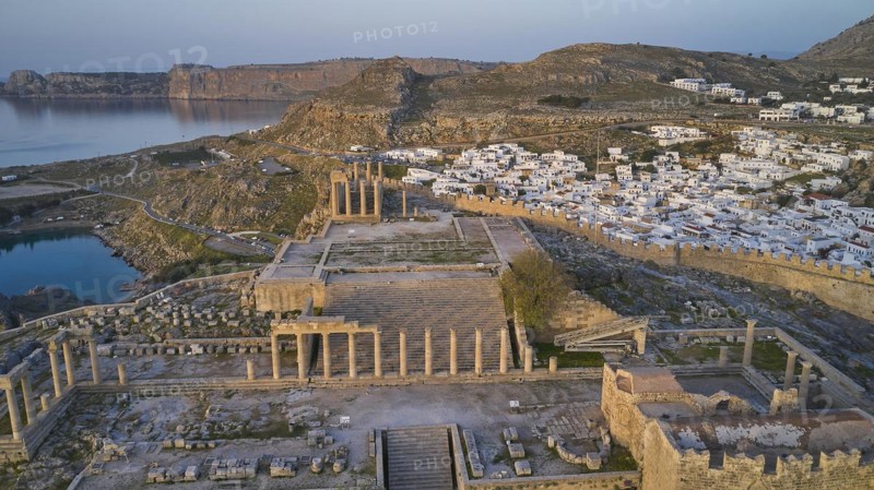Drone shot, first morning light, Lindos, Acropolis of Lindos, Propylaea with flight of steps, Temple of Athena Lindia, Ruins of ancient columns on a cliff overlooking the sea at dusk, Archaeological site, Lindos, Rhodes, Dodecanese, Greek Islands, Greece, Europe