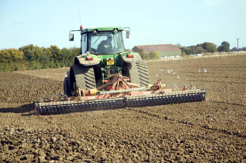 Tractor harrowing field, Parham, Suffolk, England, United Kingdom, Europe
