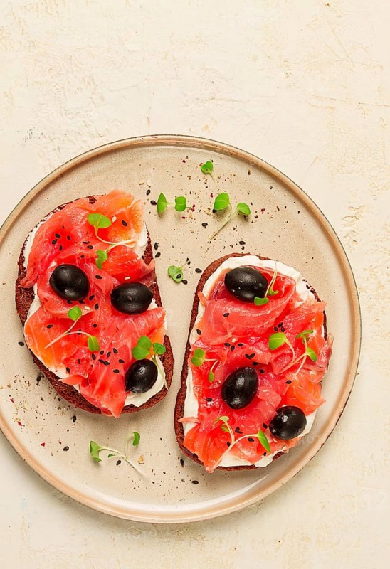 Sandwiches with red fish, cream cheese, olives and microgreens, breakfast