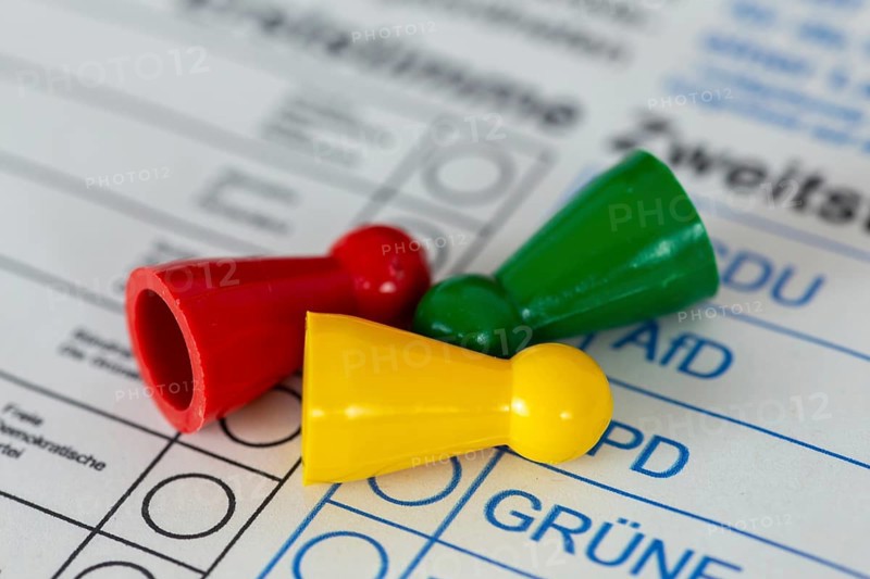 Symbolic image of poll results and election results of the traffic light government: overturned game pieces in the colours red (SPD), green (The Greens) and yellow (FDP)