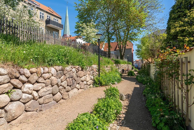 Rosenbækken, cultural-historical site, course of the moat in the Middle Ages, today the old town centre of Nyborg, town history 15th century, path, church tower, lanterns, stone wall, Fyn, Fyn Island, Denmark, Europe