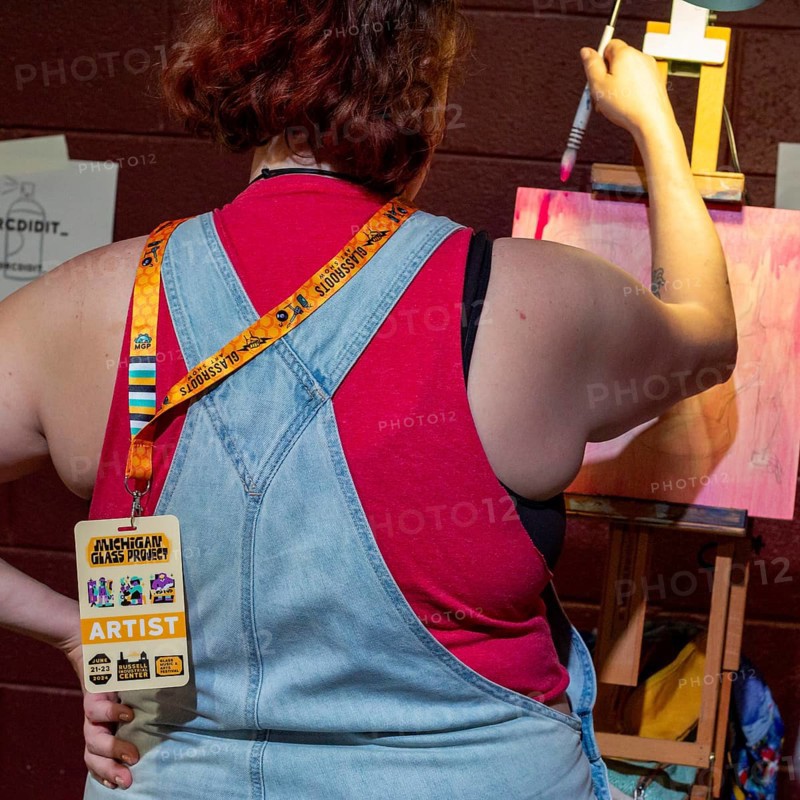 Detroit, Michigan, An artist creates a painting at the Michigan Glass Project. Artists create glass and other artworks at the annual show. The event raises money to support art education in Detroit-area schools