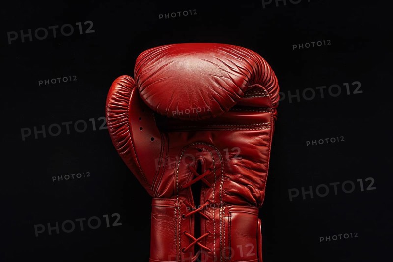 Bright red boxing glove on studio background. Generative AI, AI generated