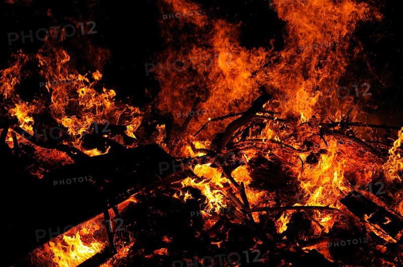 Intense flames and embers surround burning wood in the dark, campfire, Easter fire, Bavaria