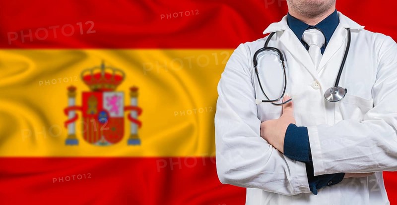Male doctor with stethoscope on Spain flag. Doctor holding stethoscope on Spanish flag
