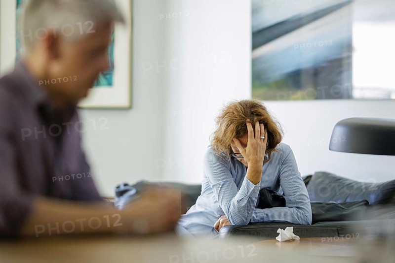 Symbolic photo on the subject of problems in a partnership. An older woman and an older man sitting at home. Berlin, 13.08.2024