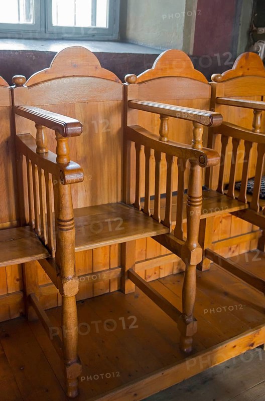 Traditional wooden church pews in a warm, stylish church interior, Suzana Orthodox Nunnery, Maneciu, Maneciu, Prahova, Muntenia, Romania, Europe
