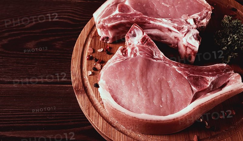 Fresh, raw pork meat, sliced, on a cutting board, with spices, horizontal, rustic style, toning, no people