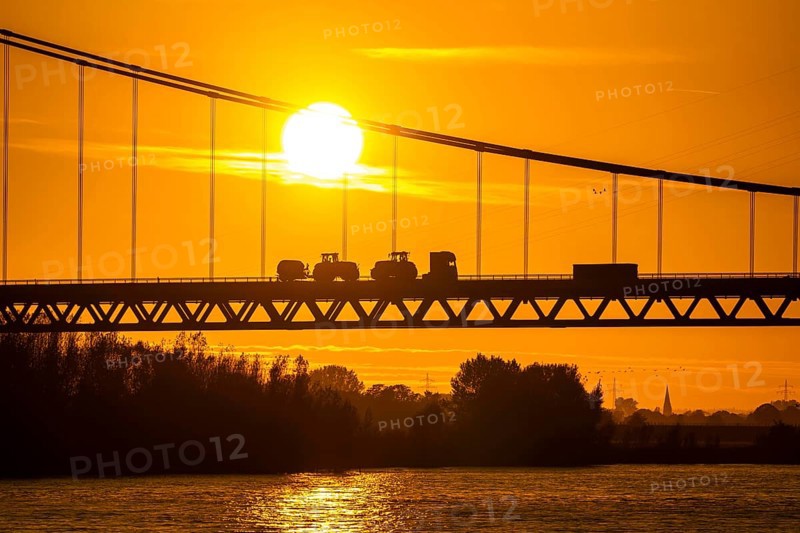 Traffic on the Rhine bridge Emmerich, federal road B220, evening light, with 803 m the longest suspension bridge in Germany shortly in front of the Dutch border, Rhine kilometre 853, 2 it is the northernmost German Rhine bridge, North Rhine-Westphalia, Germany, Europe