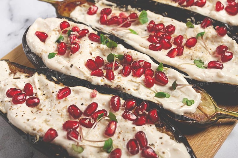 Fried eggplant with sauce, decorated with microgreens and pomegranate seeds, eggplant appetizer, top view, homemade, no people