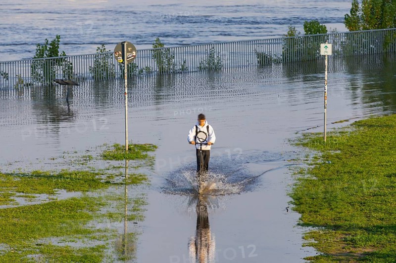 A weather-determining low-pressure system is moving from northern Italy on a so-called Vb track via Austria and the Czech Republic to Poland, bringing very humid air with it. This will also lead to flooding in the Elbe in Saxony. On 18.9.24, the level of the Elbe in Dresden is 6.06m. An e-scooter rider tries to cross the closed Elbe cycle path, Elbe floods in Dresden, Dresden, Saxony, Germany, Europe
