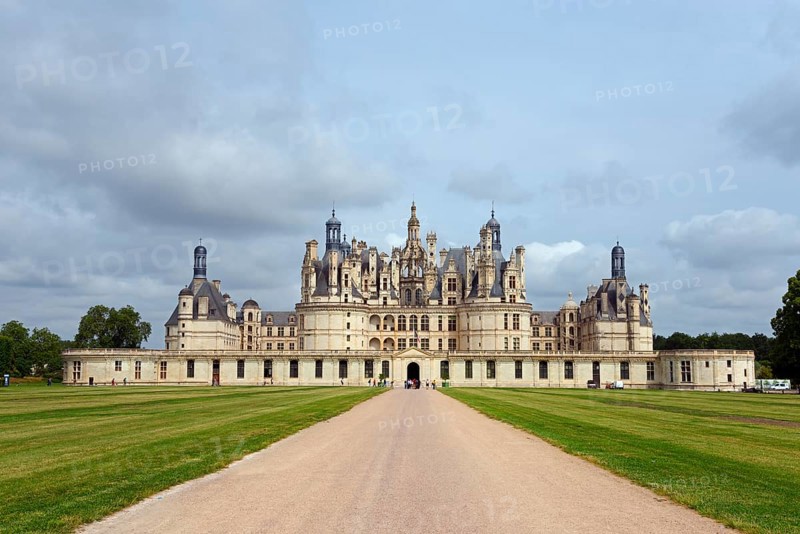 Large historic castle with many towers and decorations, situated along a long path, surrounded by manicured lawns and a cloudy sky, Chambord Castle, Château de Chambord, Loire Castle, Loire Valley, Loir-et-Cher Department, Centre Region, France, Europe