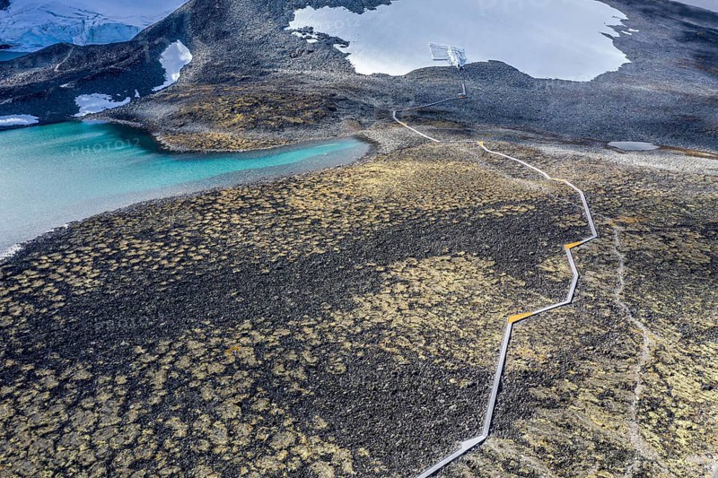 Aerial view of planked path and gravel road in norwegian mountains, path from Juvasshytta to Klimapark 2469 ice tunnel and glacier cave, Jotunheimen, Norway, Europe