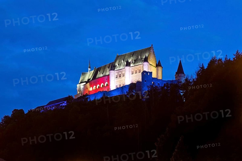 Vianden Castle, hilltop castle illuminated in the colours of the Luxembourg flag for the bank holidays, Vianden, Grand Duchy of Luxembourg