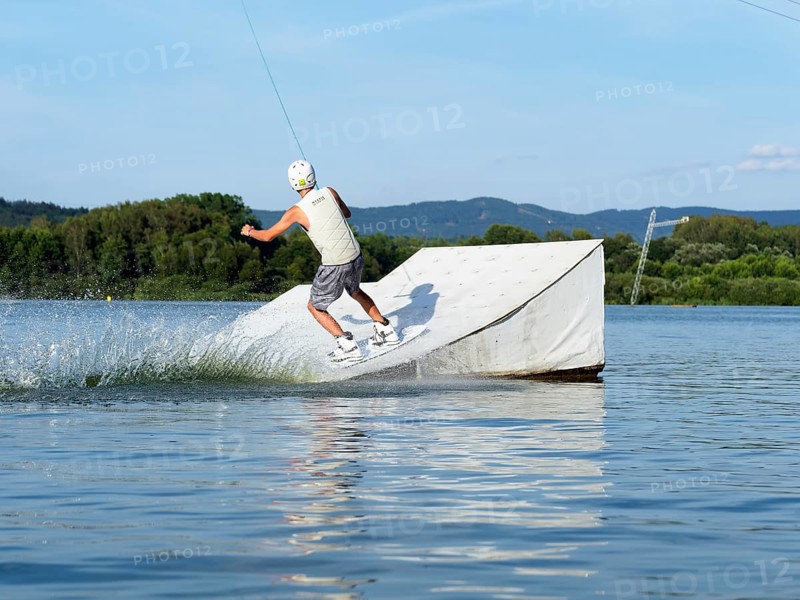 Sporty young man with wakeboard, jump over obstacle, jump, water sports, water skiing and wake park, Stráž pod Ralskem, Czech Republic, Europe