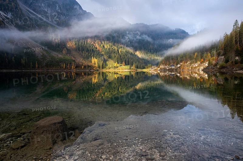 The Vordere Gosausee in autumn with a view of the Gasthof Gosausee. Sun and clouds. Overcast. Reflection. Vorderer Gosausee, Gosau, Gosau Valley, Salzkammergut, Upper Austria, Austria, Europe