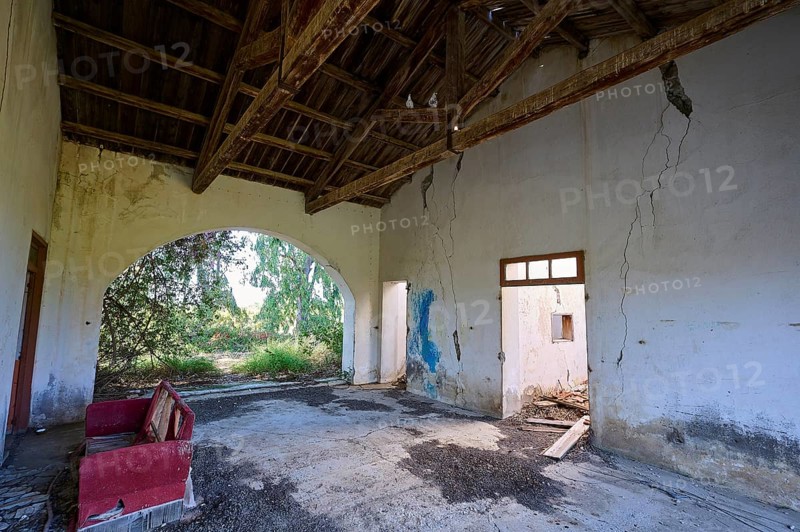 Abandoned building with cracks in the walls and a dilapidated interior. A passageway surrounded by plants leads into the greenery, Lost Place, World War II bunker, barracks, Kalavarda, Rhodes, Dodecanese, Greek Islands, Greece, Europe