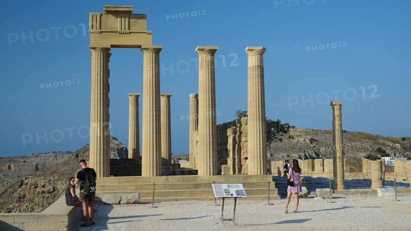 Tourists visit the ancient ruins of Lindos under a bright blue sky, Acropolis of Lindos, morning light, Temple of Athena Lindia, Lindos, Rhodes, Dodecanese, Greek Islands, Greece, Europe