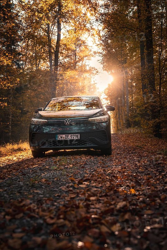 Car on a forest path covered with leaves in warm sunlight, peaceful atmosphere, electric car VW ID5, Gechingen, Black Forest, Germany, Europe