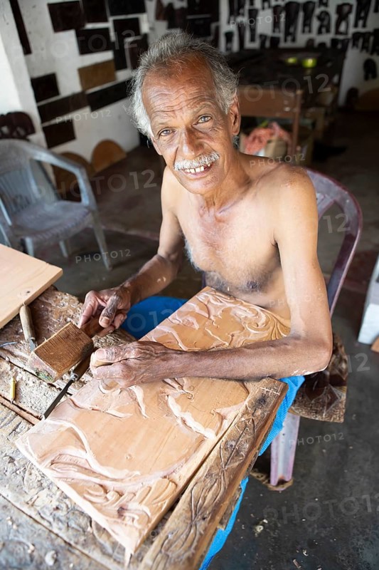 Sri Lankan man with bare upper body carving a wooden picture, Kandy, Central Province, Sri Lanka, Asia