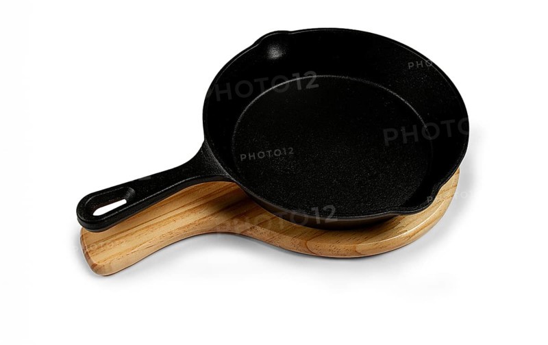 Portioned cast iron frying pan, on a wooden stand, new, on a white background, isolate