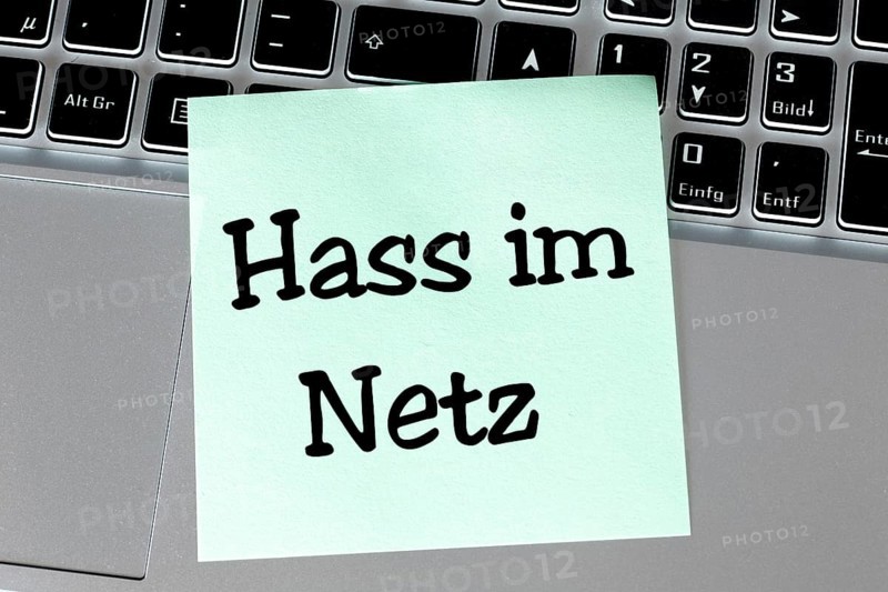 Note with the inscription HASS IM NETZ on the keyboard of a laptop